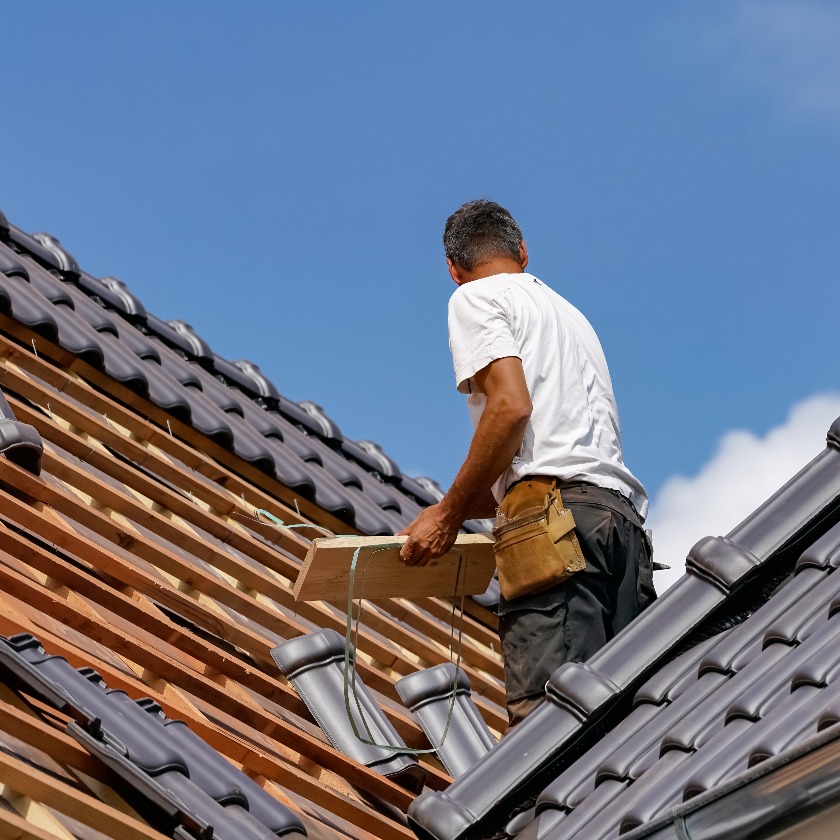 Handwerk - Dachdecker beim Eindecken eines Wohnhauses